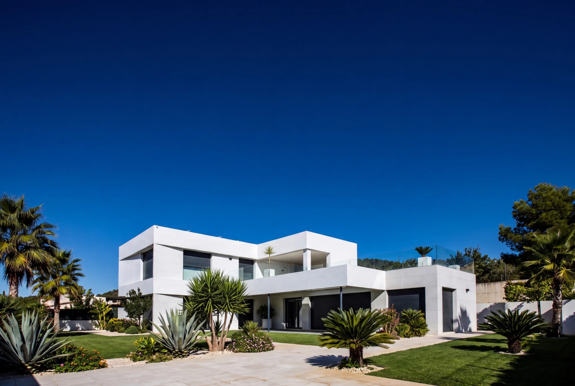 Casa branca moderna com jardim sob céu azul