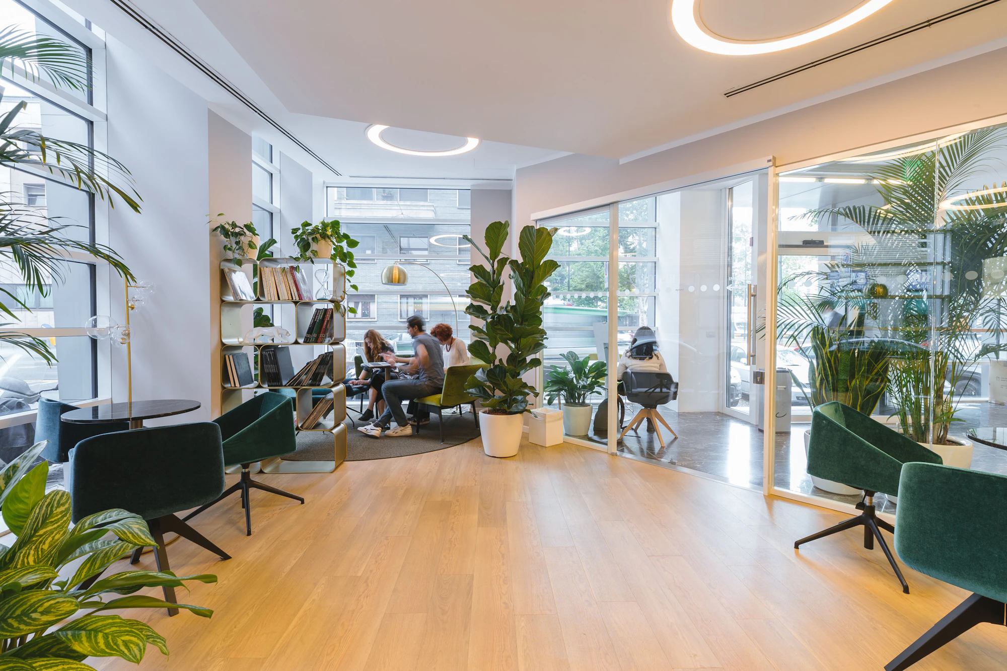 Escritório claro com plantas e poltronas verdes